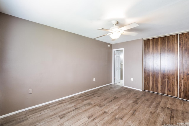 unfurnished bedroom featuring ceiling fan, light hardwood / wood-style floors, and a closet