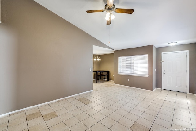 tiled spare room with lofted ceiling and ceiling fan with notable chandelier