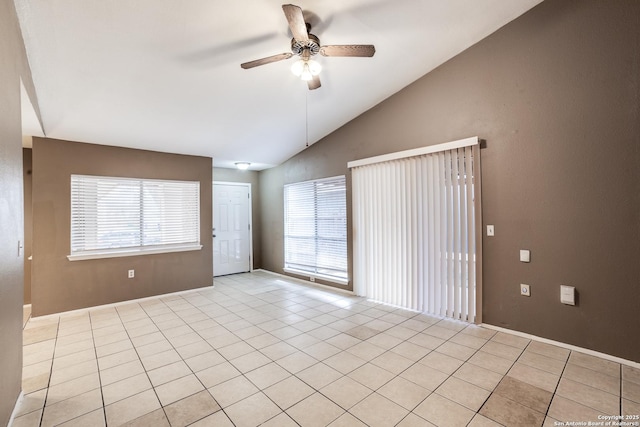 empty room with ceiling fan, lofted ceiling, and light tile patterned floors