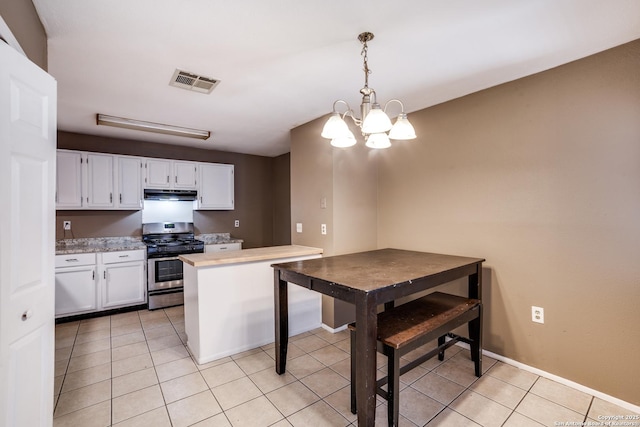 kitchen with white cabinetry, gas range, pendant lighting, and light tile patterned floors