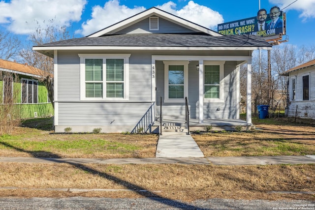 bungalow-style house featuring covered porch and a front lawn