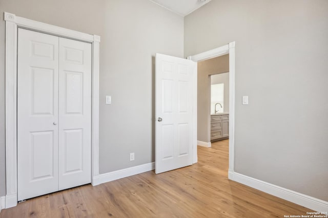 unfurnished bedroom featuring sink, light hardwood / wood-style floors, and a closet