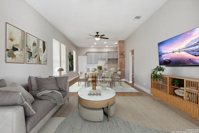 living room featuring ceiling fan and wood-type flooring