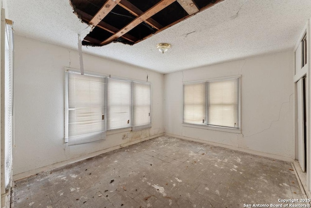 unfurnished room with a textured ceiling