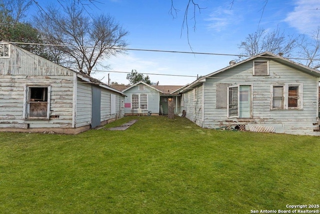 rear view of property with a yard