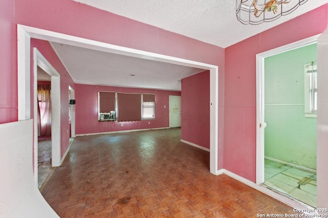 spare room with parquet flooring and a textured ceiling