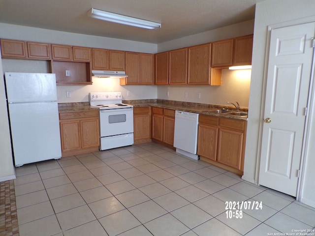 kitchen with white appliances, sink, and light tile patterned floors