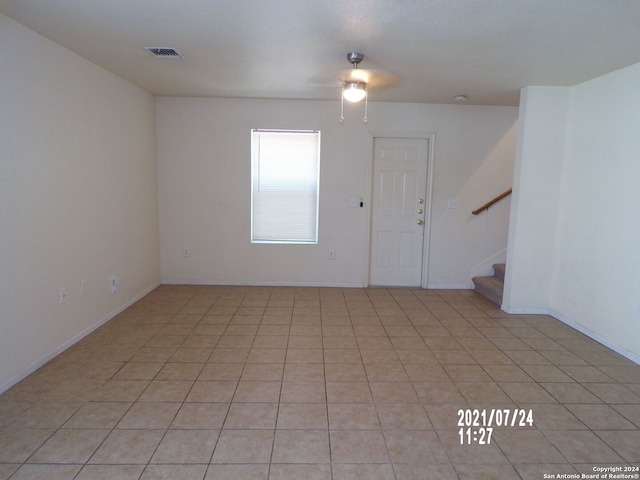 tiled empty room with ceiling fan