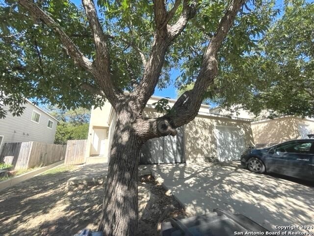 view of property hidden behind natural elements with a garage