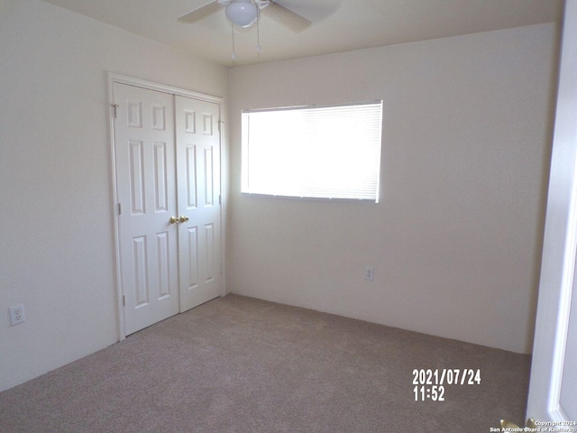 carpeted spare room with ceiling fan