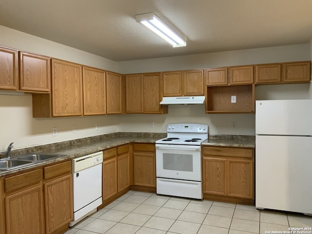 kitchen featuring light tile patterned flooring, sink, a textured ceiling, and white appliances