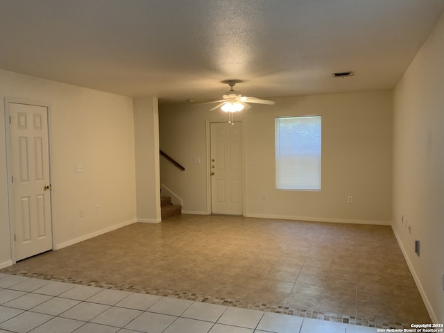 tiled empty room with ceiling fan