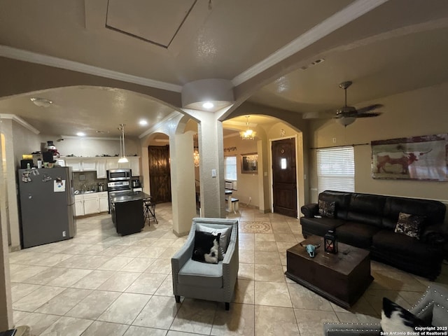 tiled living room with crown molding and ceiling fan