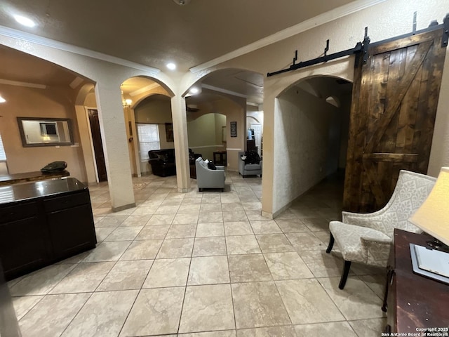 interior space with crown molding, a barn door, and light tile patterned flooring