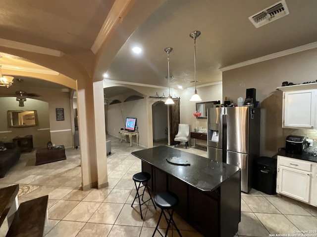 kitchen featuring a breakfast bar area, white cabinets, hanging light fixtures, a center island, and stainless steel fridge with ice dispenser