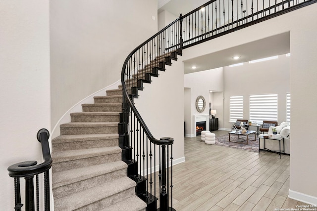 stairway featuring hardwood / wood-style flooring and a towering ceiling