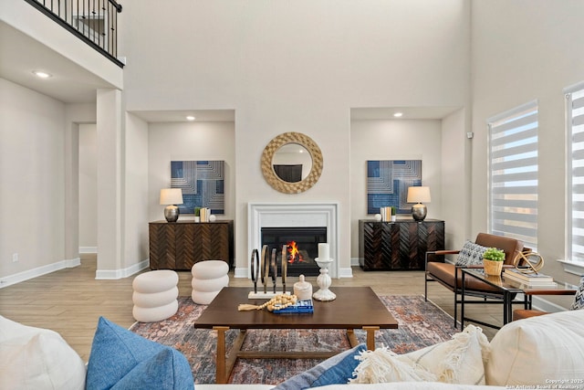 living room with a high ceiling and light hardwood / wood-style flooring