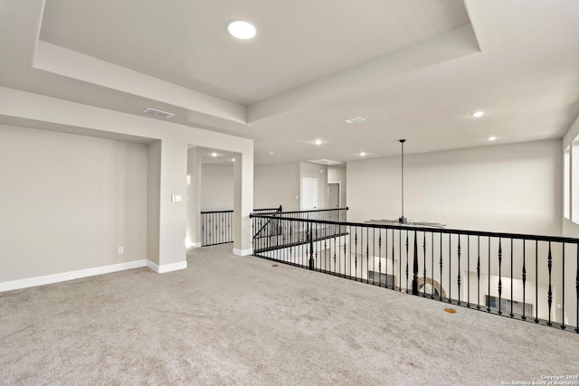 empty room featuring carpet floors, ceiling fan, and a tray ceiling