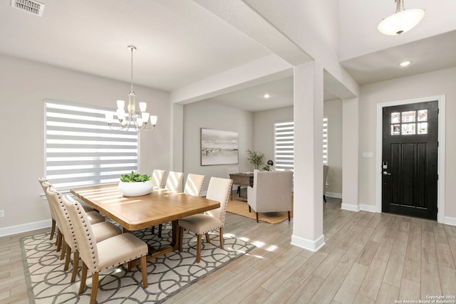 dining area featuring an inviting chandelier and light hardwood / wood-style floors