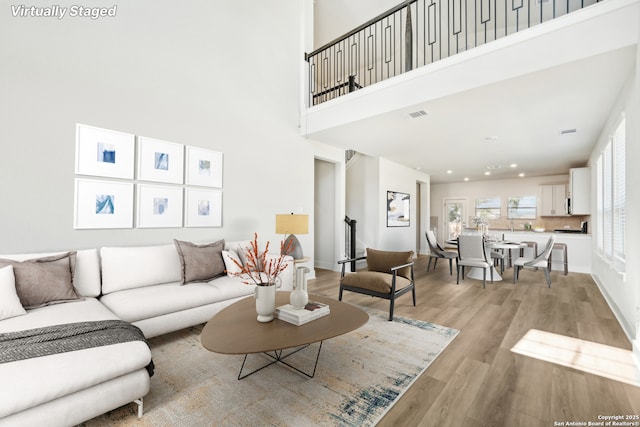 living room featuring light hardwood / wood-style floors and a high ceiling