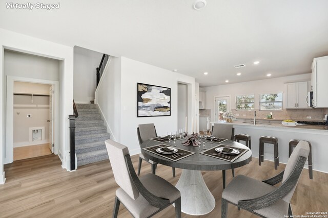 dining space with sink and light hardwood / wood-style floors