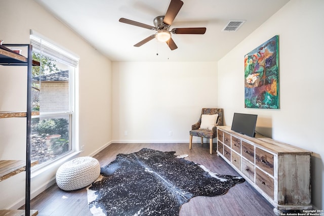 living area featuring dark hardwood / wood-style flooring and ceiling fan