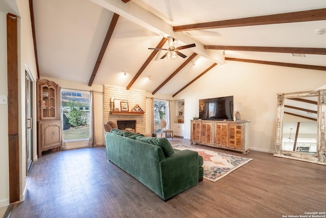 living room with lofted ceiling with beams, a brick fireplace, dark wood-type flooring, and ceiling fan