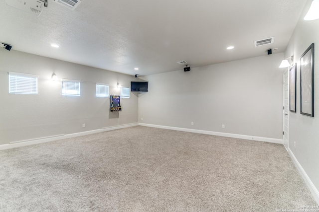 basement featuring carpet flooring and a textured ceiling