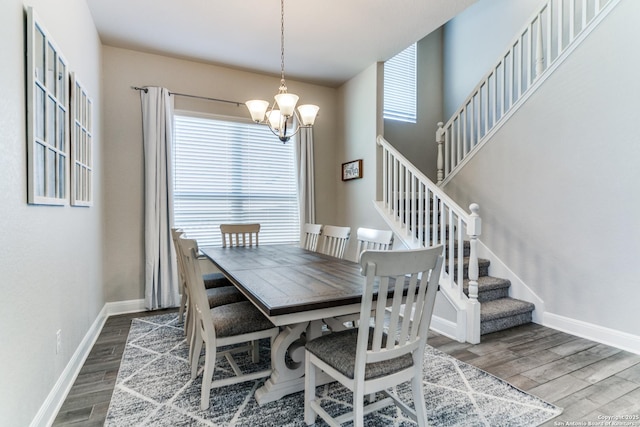 dining room with a wealth of natural light, wood-type flooring, and a chandelier