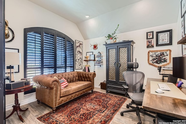 office with light hardwood / wood-style flooring and vaulted ceiling