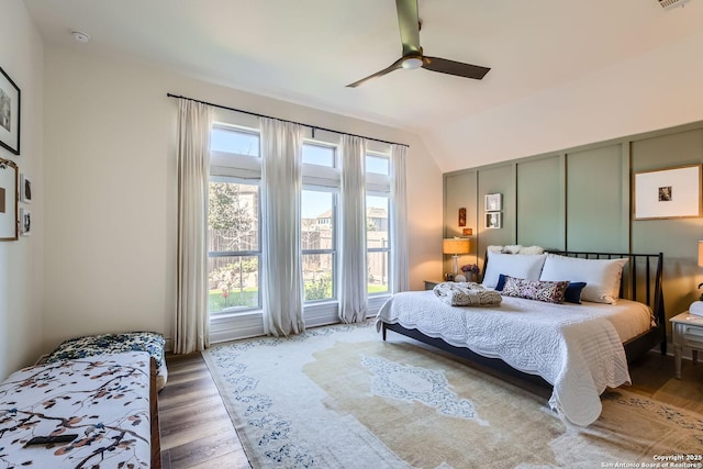 bedroom with wood-type flooring, lofted ceiling, and ceiling fan