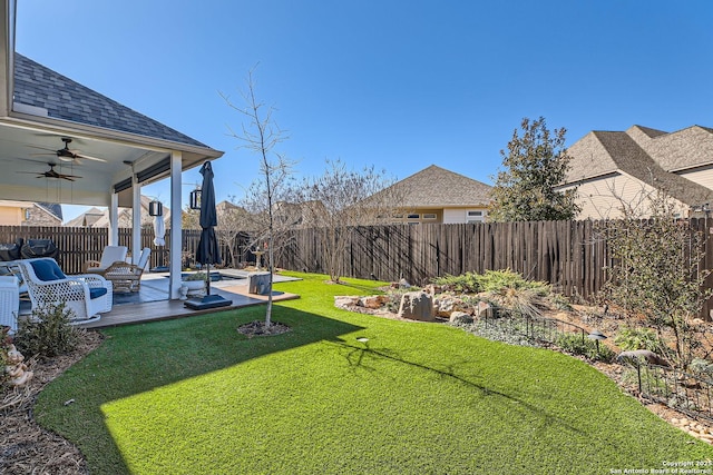 view of yard with ceiling fan and a patio area