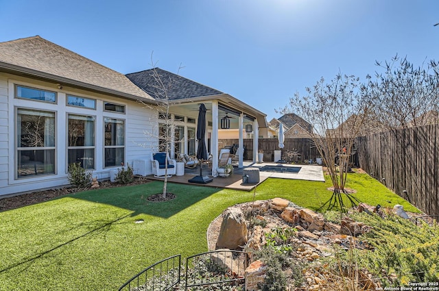 back of house with a lawn and a patio