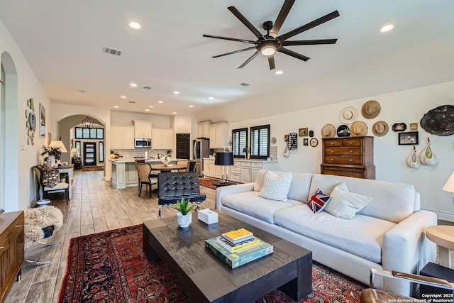 living room featuring ceiling fan and light hardwood / wood-style floors