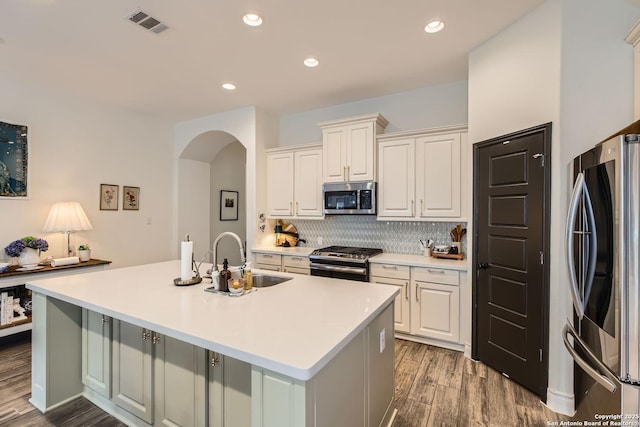 kitchen featuring sink, an island with sink, white cabinets, and appliances with stainless steel finishes