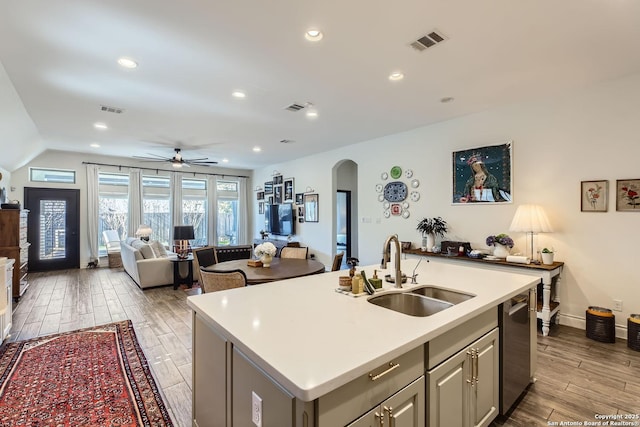 kitchen featuring sink, ceiling fan, gray cabinetry, a center island with sink, and stainless steel dishwasher