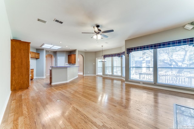 unfurnished living room with ceiling fan and light wood-type flooring