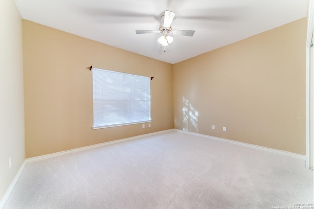 carpeted spare room with ceiling fan