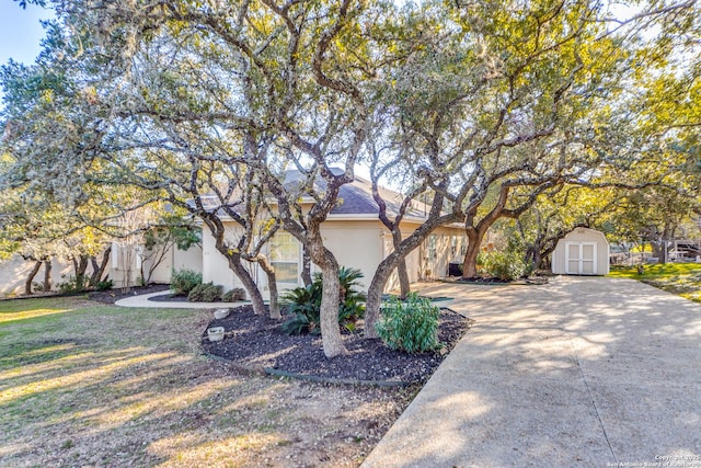 view of front of property featuring a front lawn and a shed