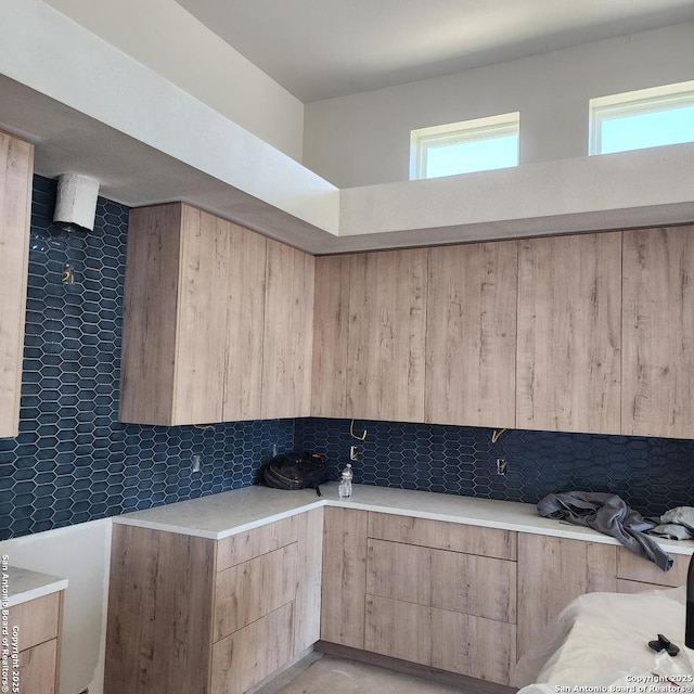 kitchen featuring a wealth of natural light, light brown cabinetry, and decorative backsplash