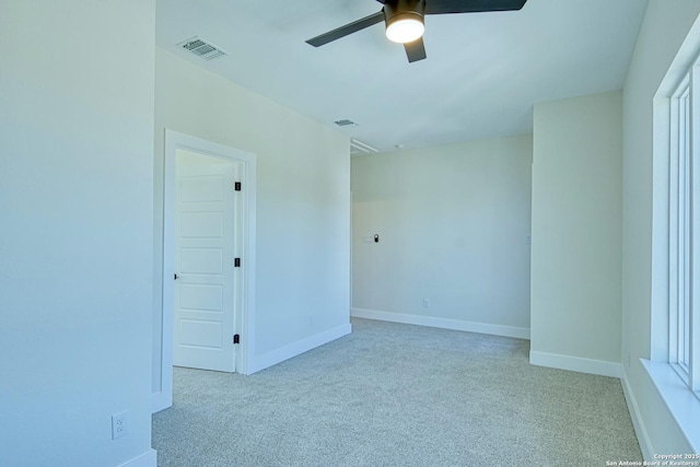 spare room featuring light colored carpet and ceiling fan