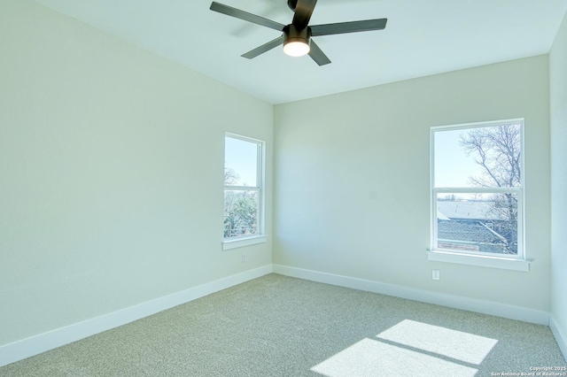 carpeted spare room with a wealth of natural light and ceiling fan