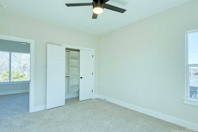 unfurnished bedroom with ceiling fan, light colored carpet, and a closet