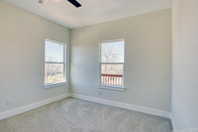 carpeted empty room with a wealth of natural light and ceiling fan