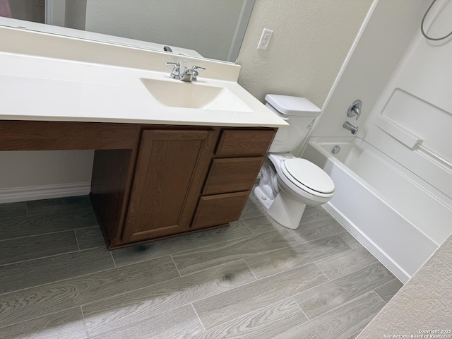 bathroom with tub / shower combination, vanity, and toilet