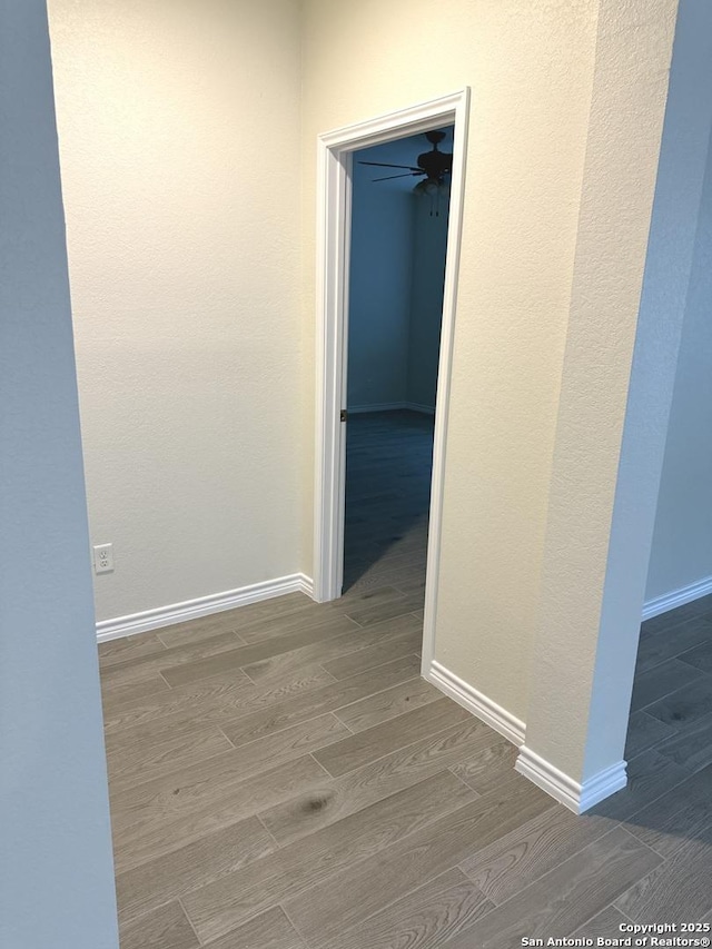 corridor with baseboards and wood tiled floor