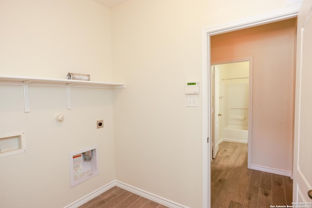 clothes washing area with laundry area, baseboards, wood finished floors, washer hookup, and electric dryer hookup