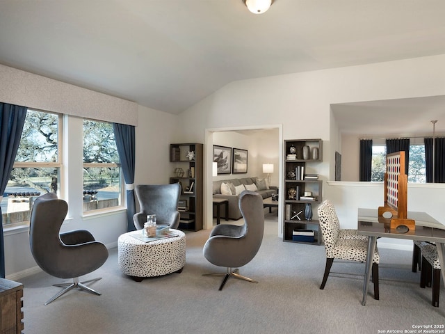 living area featuring carpet flooring, vaulted ceiling, and a wealth of natural light