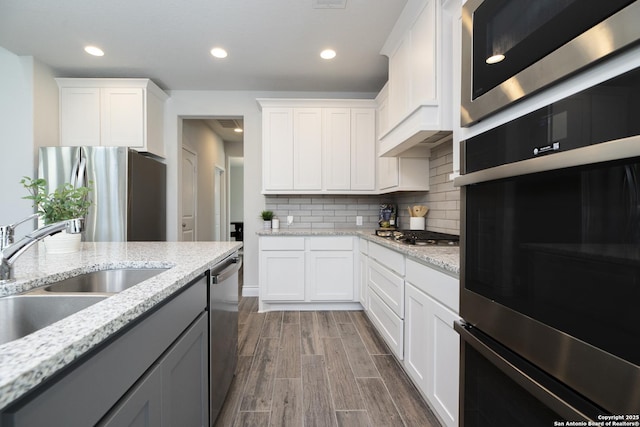 kitchen featuring white cabinetry, stainless steel appliances, sink, and hardwood / wood-style floors