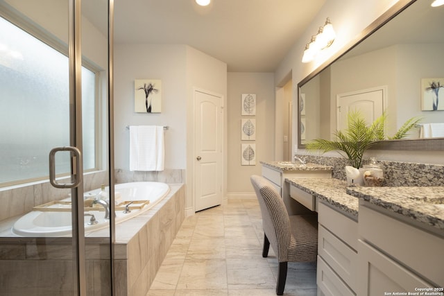 bathroom featuring vanity and tiled bath